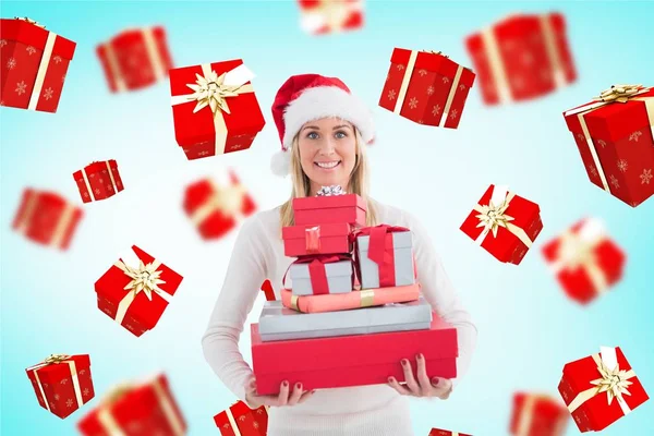 圣诞老人的帽子，拿着礼物叠的女人 — 图库照片