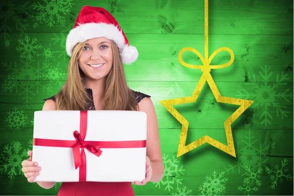 Frau mit Weihnachtsmütze hält Weihnachtsgeschenk in der Hand — Stockfoto