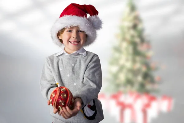 Chlapec v santa hat drží Vánoční cetka — Stock fotografie