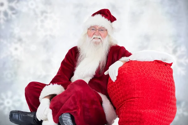 Kerstman zitten met kerst cadeau zak — Stockfoto