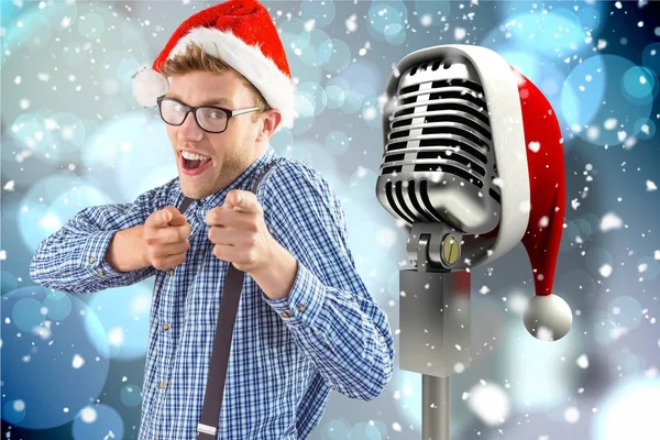 Homme geste vers microphone avec santa chapeau — Photo