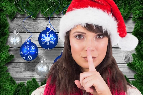 Frau mit Weihnachtsmütze und Finger auf den Lippen — Stockfoto