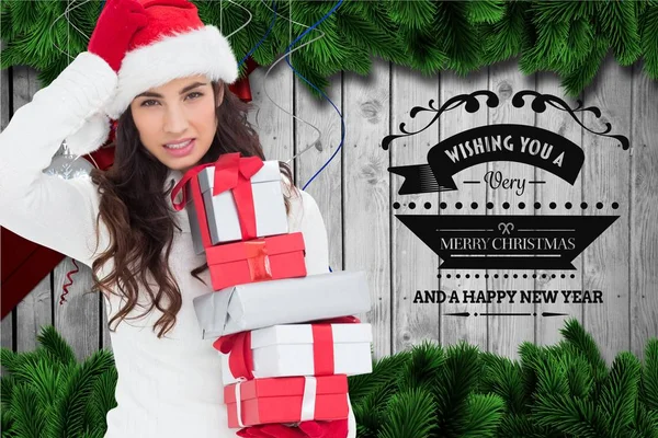 Woman in santa hat holding christmas gifts — Stock Photo, Image