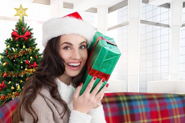 Woman in santa hat holding a gift — Stock Photo, Image