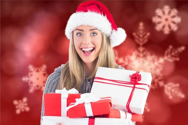 Frau mit Weihnachtsmütze hält Weihnachtsgeschenke in der Hand — Stockfoto