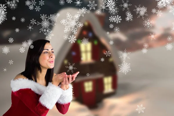 Femme en costume de Père Noël soufflant flocons de neige — Photo