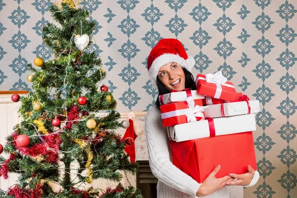 Mujer en sombrero de santa celebración pila de regalos —  Fotos de Stock