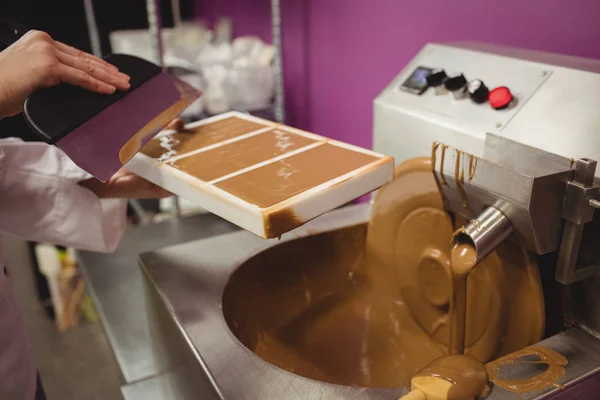 Arbeiter füllen Form mit geschmolzener Schokolade — Stockfoto