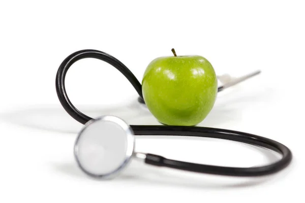Стетоскоп и яблоко на белом — стоковое фото