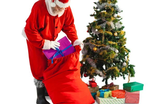 Santa claus βάζοντας παρουσιάζει σε Χριστουγεννιάτικο σάκο — Φωτογραφία Αρχείου