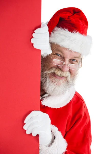 Санта Клаус подглядывает из красной доски — стоковое фото