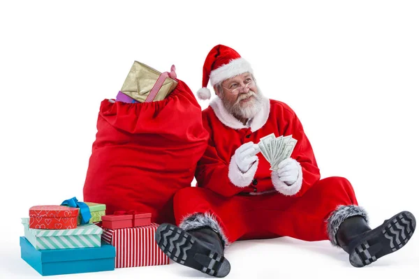 Kerstman zitten naast het geschenk tellen — Stockfoto