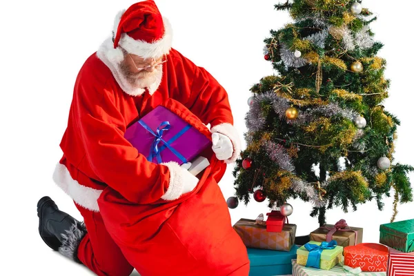 Santa claus att sätta presenterar i christmas väska — Stockfoto