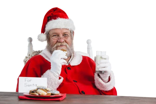 Santa claus drží Sklenka mléka — Stock fotografie