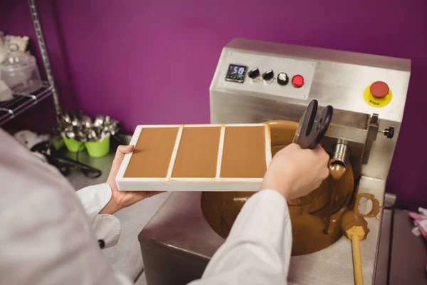 Pracownik wypełnienie formy z rozpuszczoną czekoladę — Zdjęcie stockowe