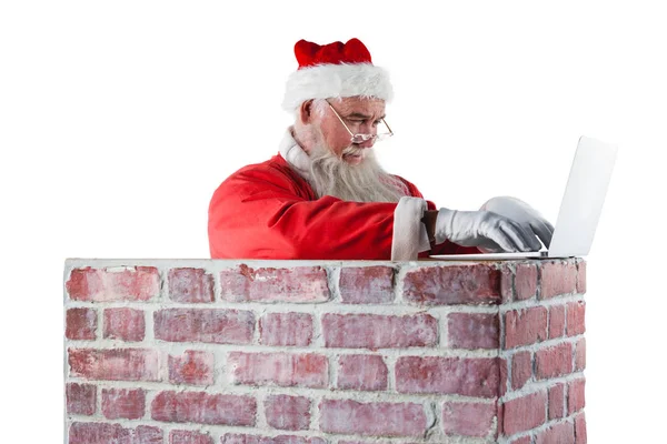 Santa claus met behulp van laptop — Stockfoto