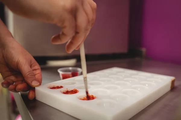 Trabalhador pintando um molde de chocolate — Fotografia de Stock