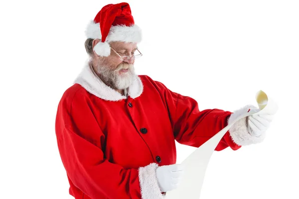 Santa claus smiling and reading a scroll — Stock Photo, Image