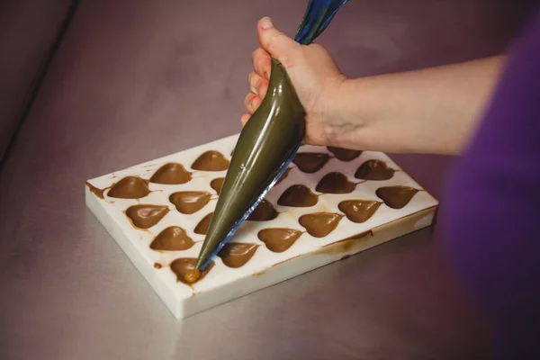 Worker filling mould with piping bag — Stock Photo, Image