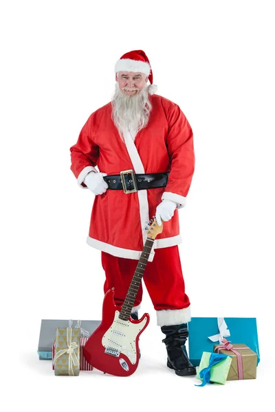 Santa Claus de pie con guitarra y varios regalos — Foto de Stock