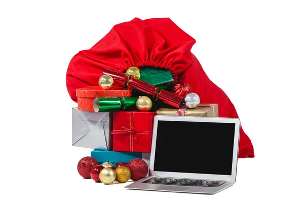 Santa bag filled with surprised gifts and laptop — Stock Photo, Image