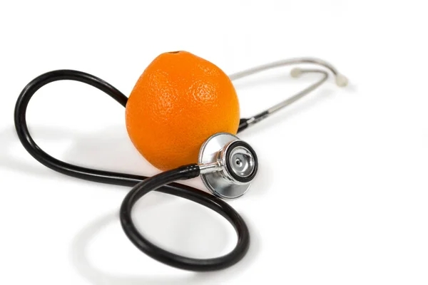 Стетоскоп и апельсин на белом — стоковое фото
