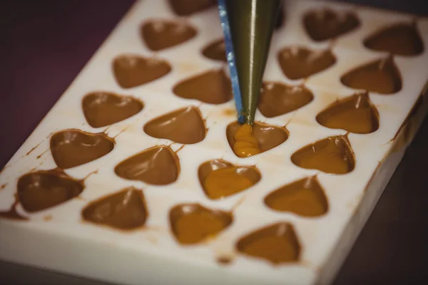 Filling a chocolate mould with a piping bag — Stock Photo, Image