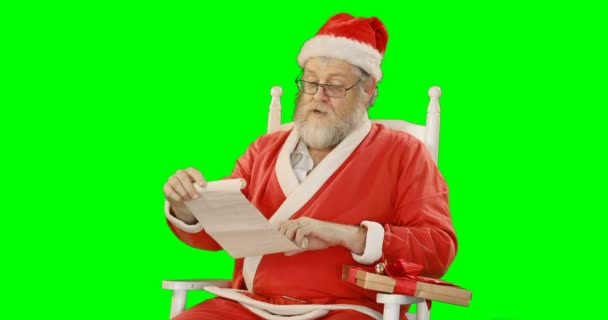Санта-Клаус держит свиток и подарочную коробку — стоковое видео