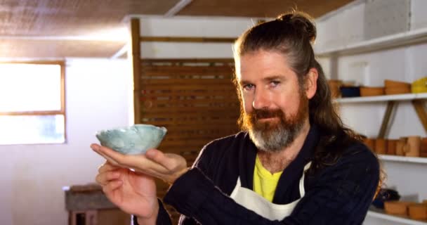 Happy male potter holding bowl — Stock Video