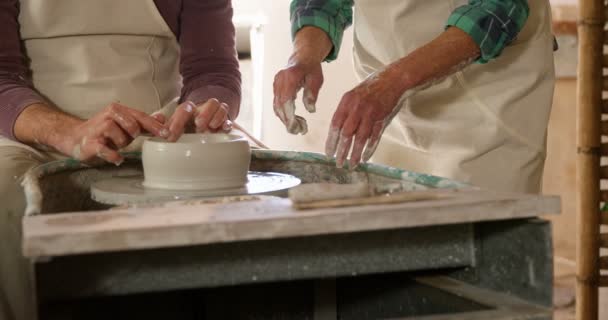 Mannelijke potter bijstaan van vrouwelijke potter — Stockvideo