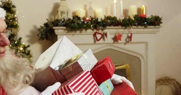 Santa Claus sosteniendo varias cajas de regalo — Vídeos de Stock