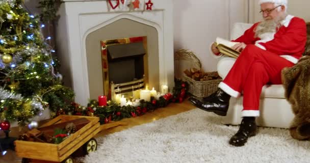Weihnachtsmann liest einen Roman — Stockvideo