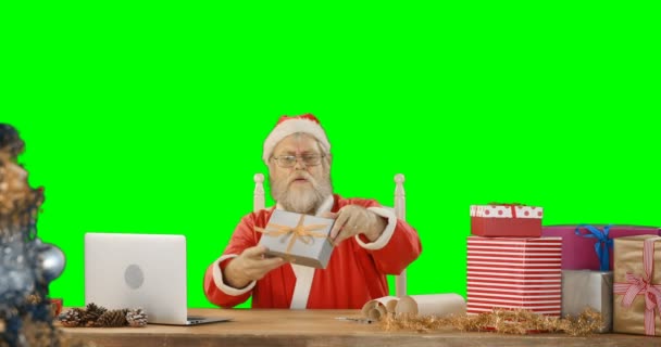 Santa Claus usando el ordenador portátil mientras marca la caja de regalo — Vídeo de stock