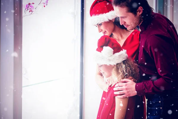 Family in christmas attire looking at display — Stock Photo, Image