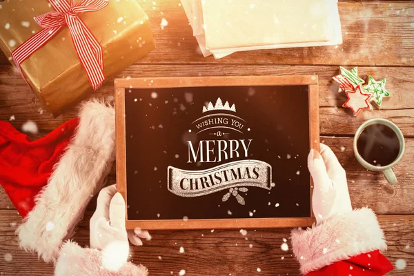 Santa claus houden van leisteen met vrolijk kerstfeest — Stockfoto