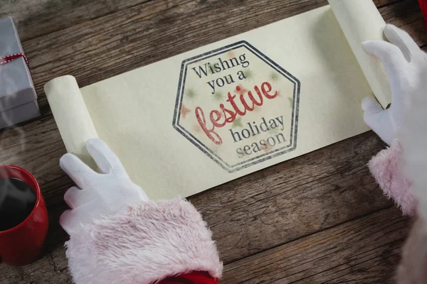 Weihnachtsmann öffnet Schriftrolle — Stockfoto