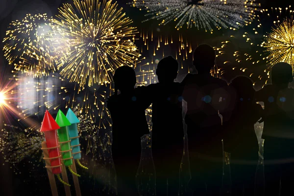 Crianças silhuetas contra fogos de artifício coloridos — Fotografia de Stock