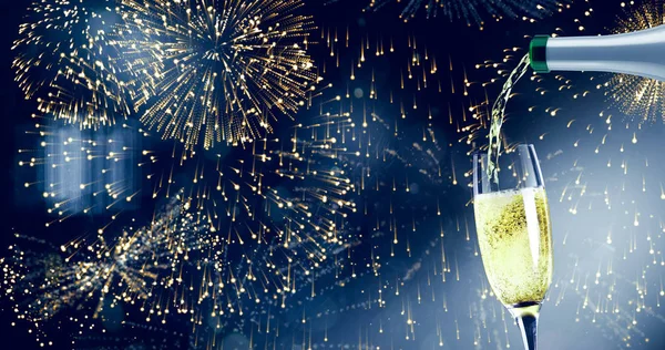 Champagne pouring against colourful fireworks — Stock Photo, Image