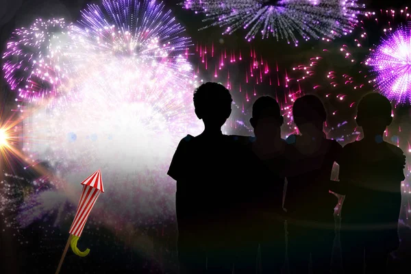Crianças silhuetas contra fogos de artifício coloridos — Fotografia de Stock