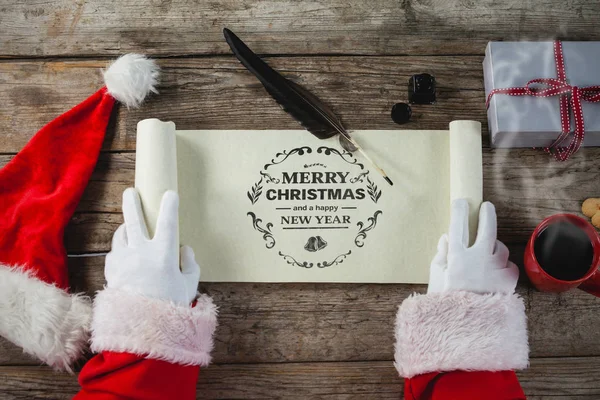 Weihnachtsmann öffnet Schriftrolle — Stockfoto