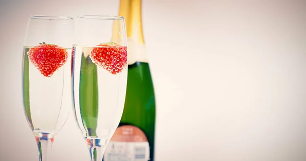 Champagne flutes with floating strawberries — Stock Photo, Image