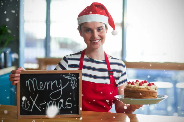 女服务员抱着石板与快乐圣诞节标志 — 图库照片