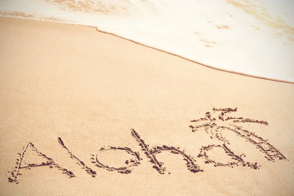 Aloha tekst napisany na piasku z palmy — Zdjęcie stockowe