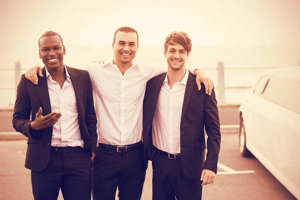 Gutaussehende Männer posieren neben Limousine — Stockfoto