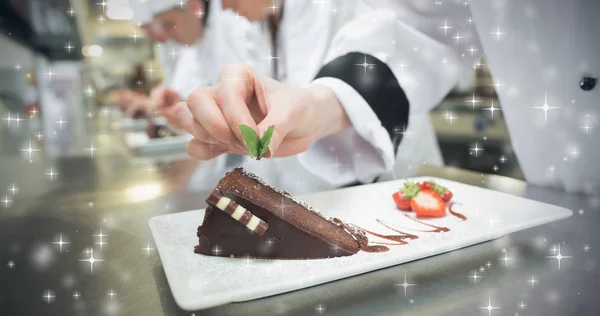 Chef putting mint leaf on chocolate cake — Stock Photo, Image