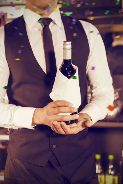 Бармен держит бутылку вина — стоковое фото