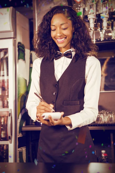 Cheerful bartender writing down order — Stock Photo, Image