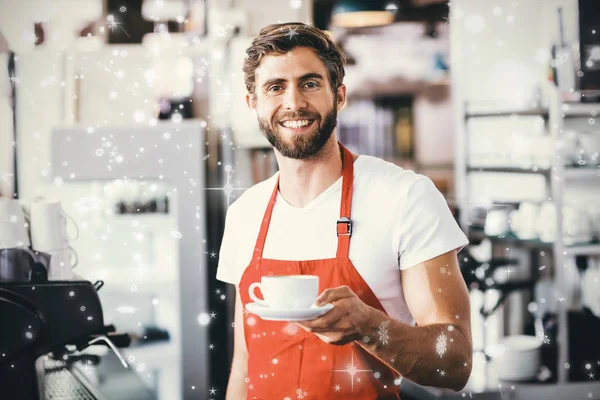 Bonito barista segurando uma xícara de café — Fotografia de Stock