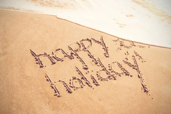 Happy holiday written text on sand — Stock Photo, Image