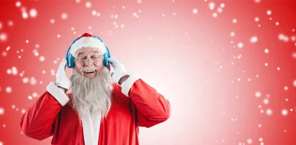 Санта Клаус слушает музыку на наушниках — стоковое фото